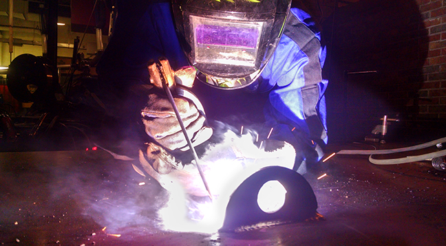 A student welding and sparks flying