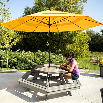 Student looking at her phone at a picnic table