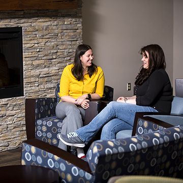 Two students talking and laughing .