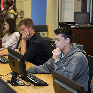 Students sitting at computers and working on their studies