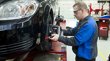 Student in the automotive lab working on a tire