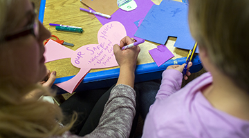 A student doing crafts and creating a Safe House heart