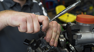 Close up of hands repairing an engine