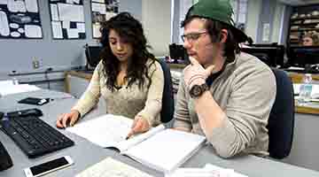 Two students working together looking at a blueprint