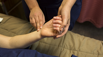 Students practicing taking the pulse of a patient