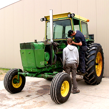 Two students working on a tractor