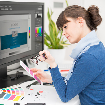 a graphic designer looking at color samples at a computer