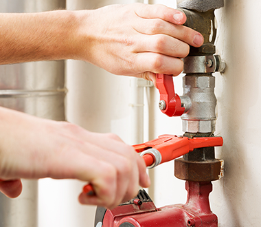 Two plumber hands work on a pipe, closeup shot