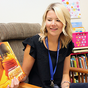 An early childhood educator reading a children's book aloud