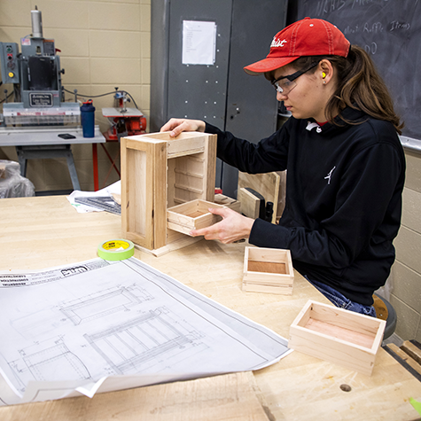 A student working on the production of a cabinet
