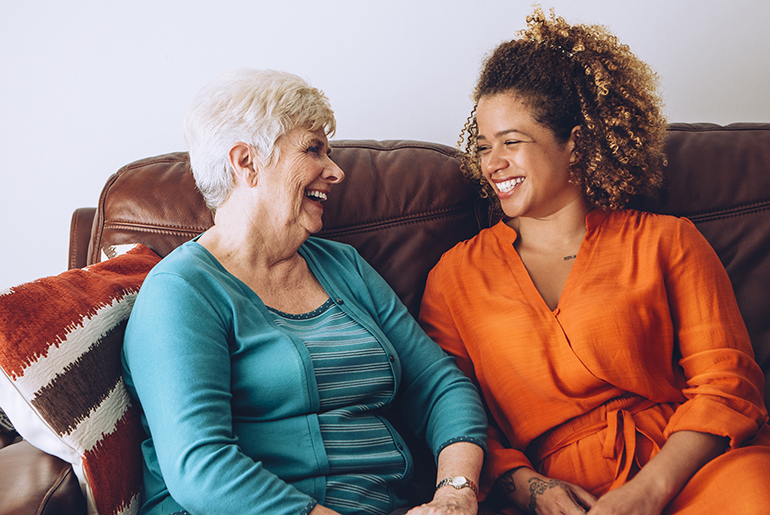 smiling caregiver sitting next to patient