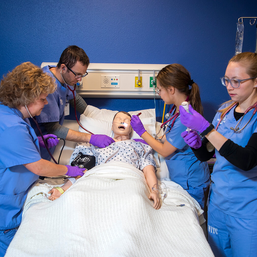 A group of nursing students working with a simulator