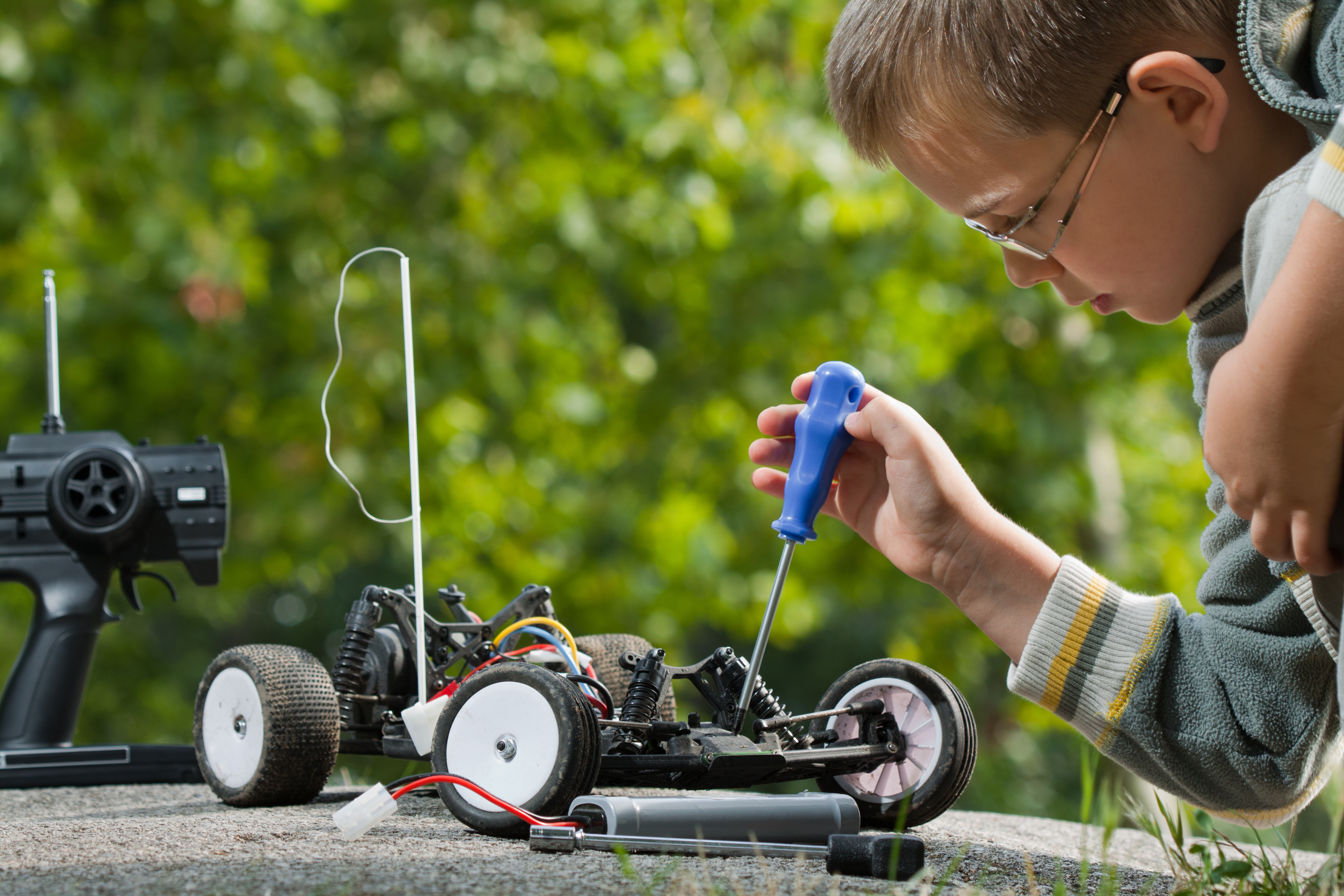 young boy outside with robotic car