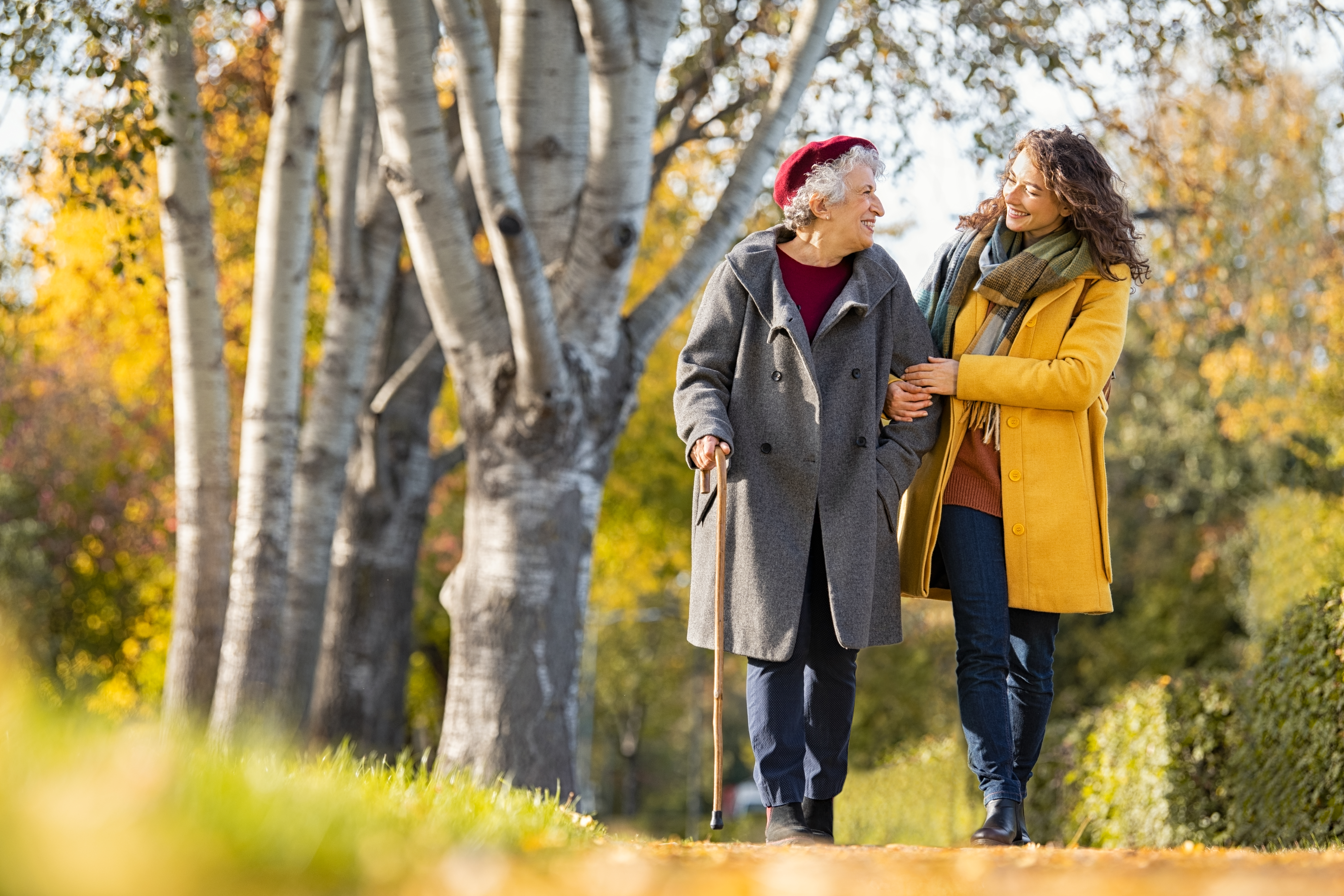 family caregiver walking with elderly woman