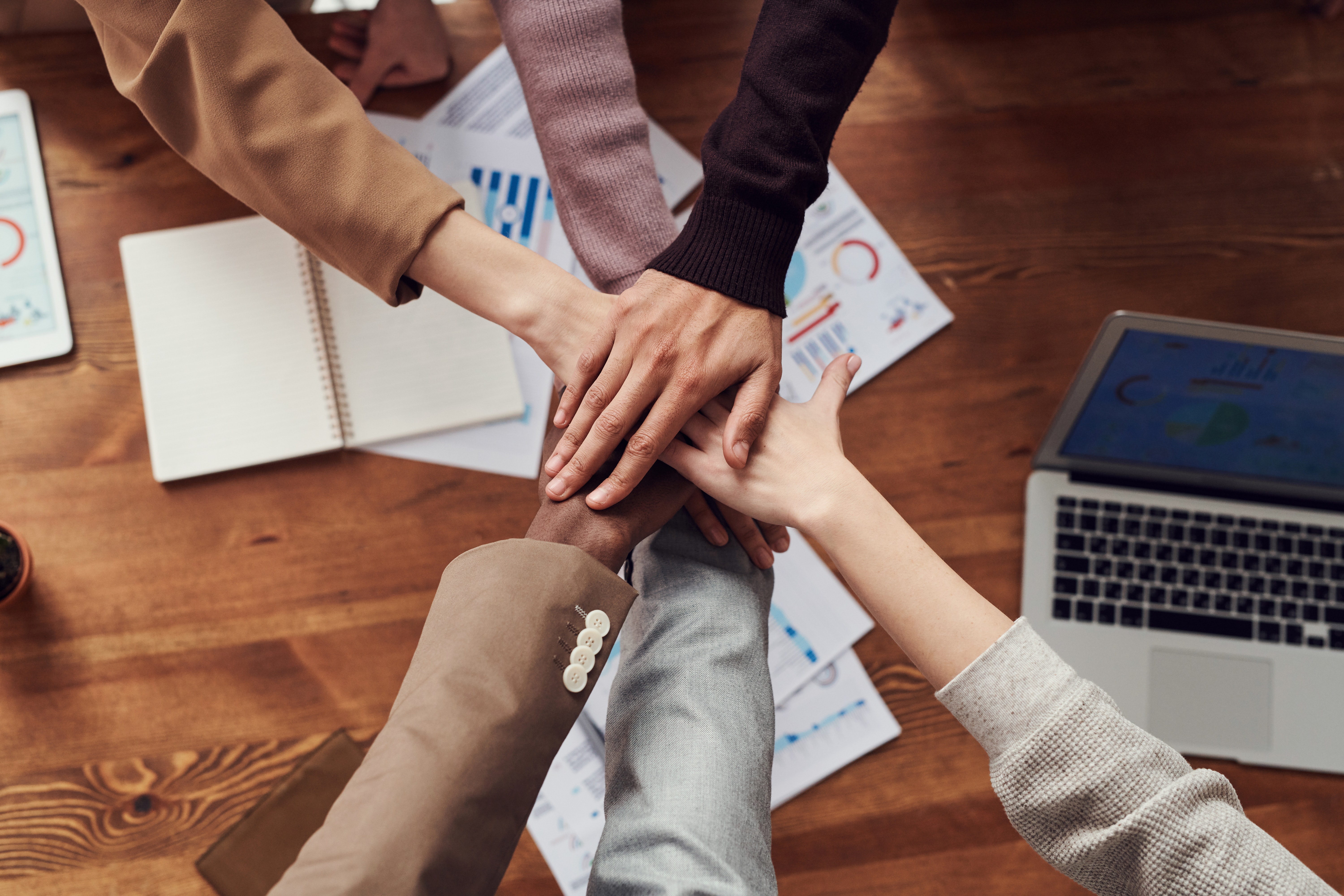 close up birdseye shot of a group of businesspeople piling their hands on top of each other