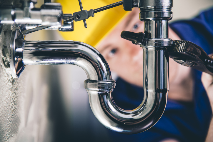 plumber working under a sink