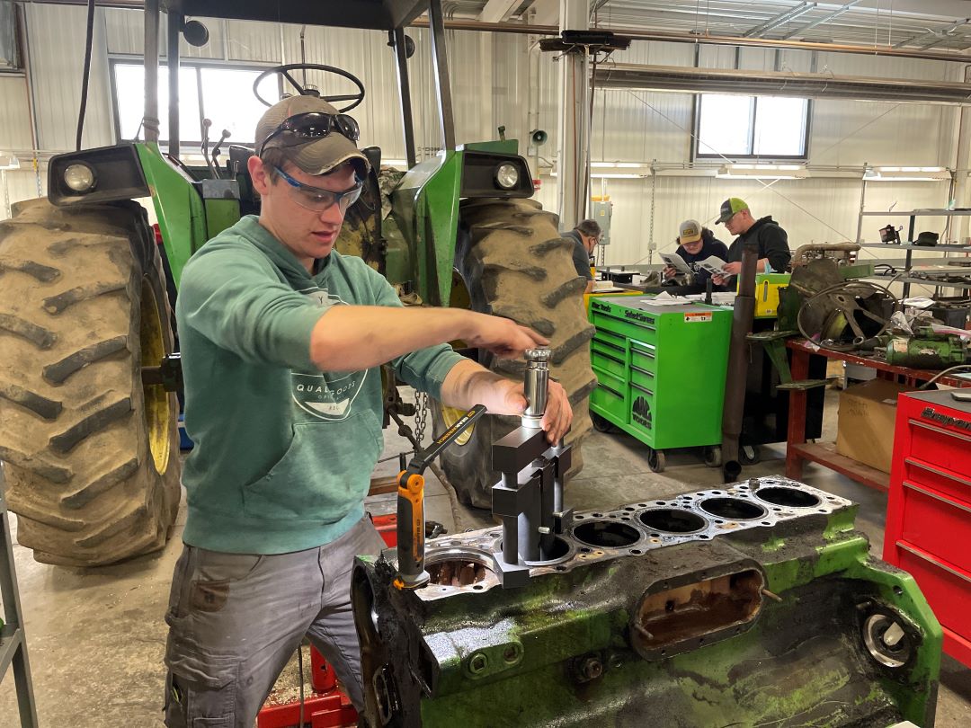 Students working on a tractor in the shop