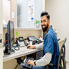 A medical office professional at his desk