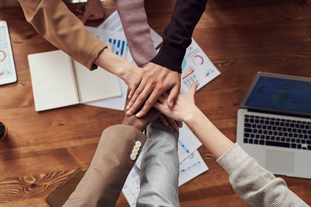 group of hands together in teamwork pile