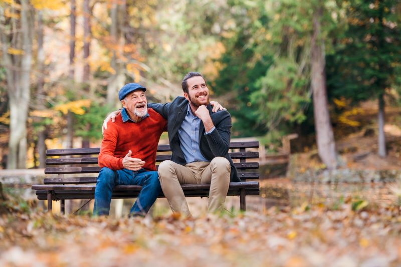 Caregiver and family member sitting outside on a bench