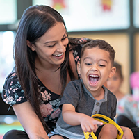 A childcare worker playing with a preschool-aged kid