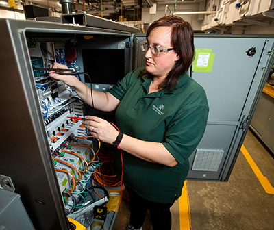 An automated packaging student working with equipment in the lab