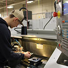 Student working on machine in classroom