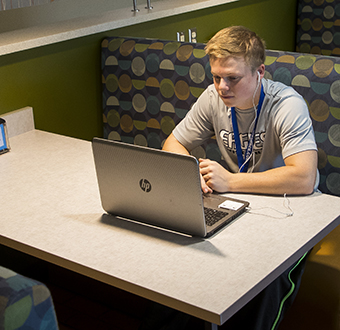 Student working on his computer at a booth in Ashland's lunchroom