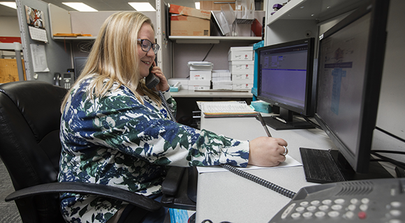 A medical administrative professional on the phone in an office