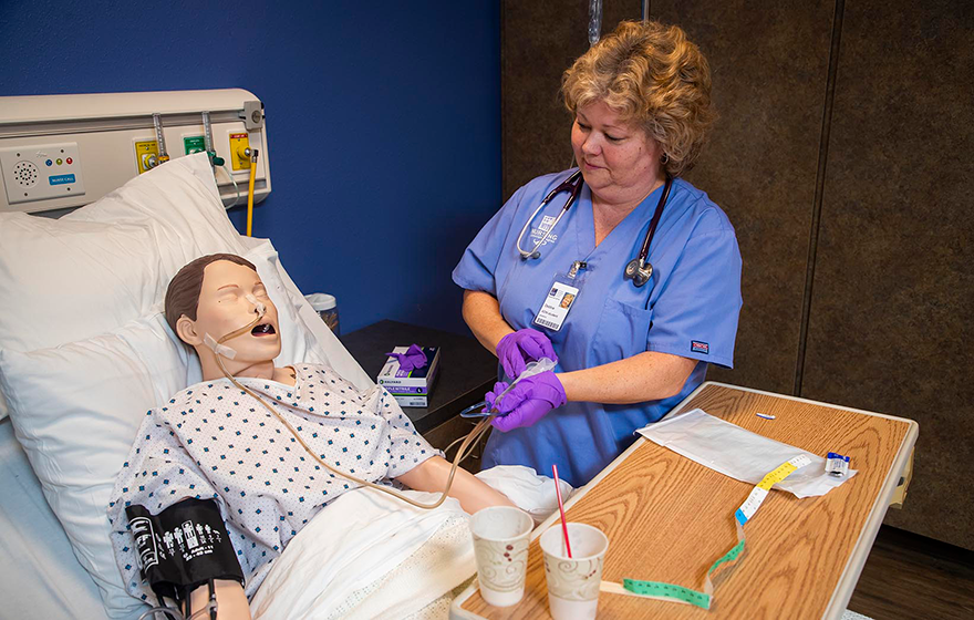 A nurse student working with a simulated patient