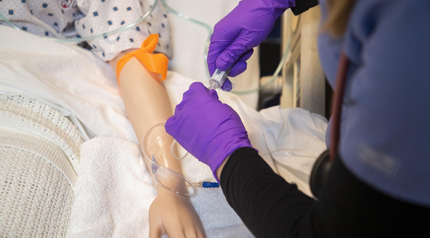 A student nurse practicing on a simulated patient