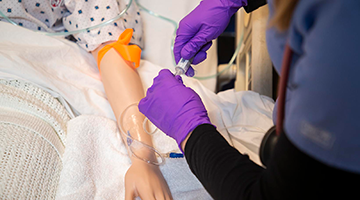 A student nurse practicing on a simulated patient