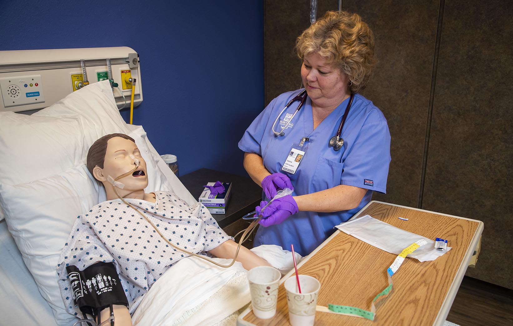 A nurse student working with a simulated patient