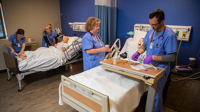 Students working in multiple groups on simulated patients