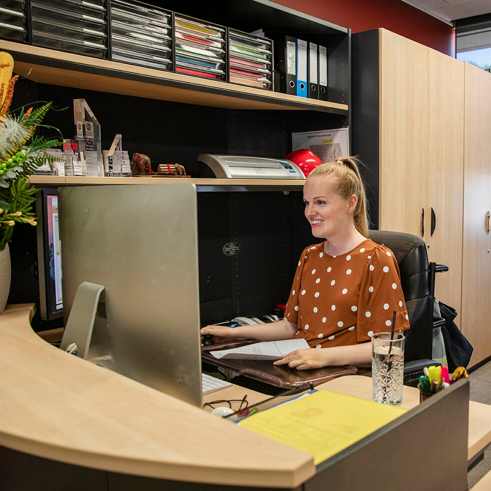 An admin coordinator working at a desk in an office