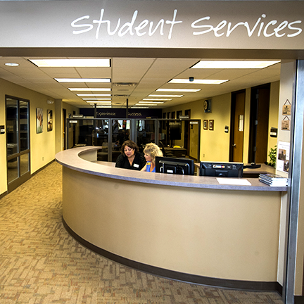Two student service employees looking at computer