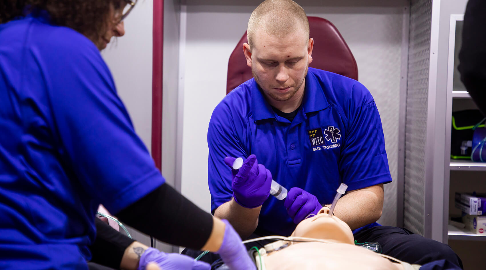 EMT students doing hands-on work with a simulated person