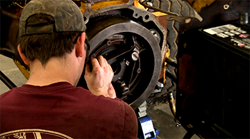 A student repairing a tractor