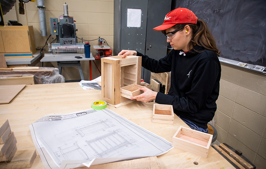 A student working on the production of a cabinet