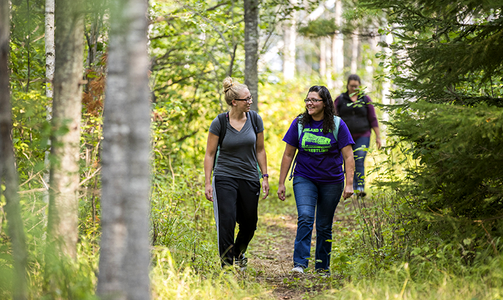 Students walking down a forested trail