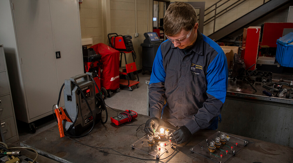 Student doing hands-on work in the automotive lab
