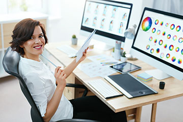 A graphic designer at the computer working on a project