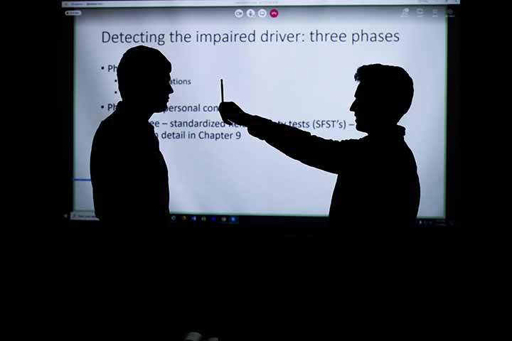 Silhouette of students doing hands-on work in the criminal justice studies classroom