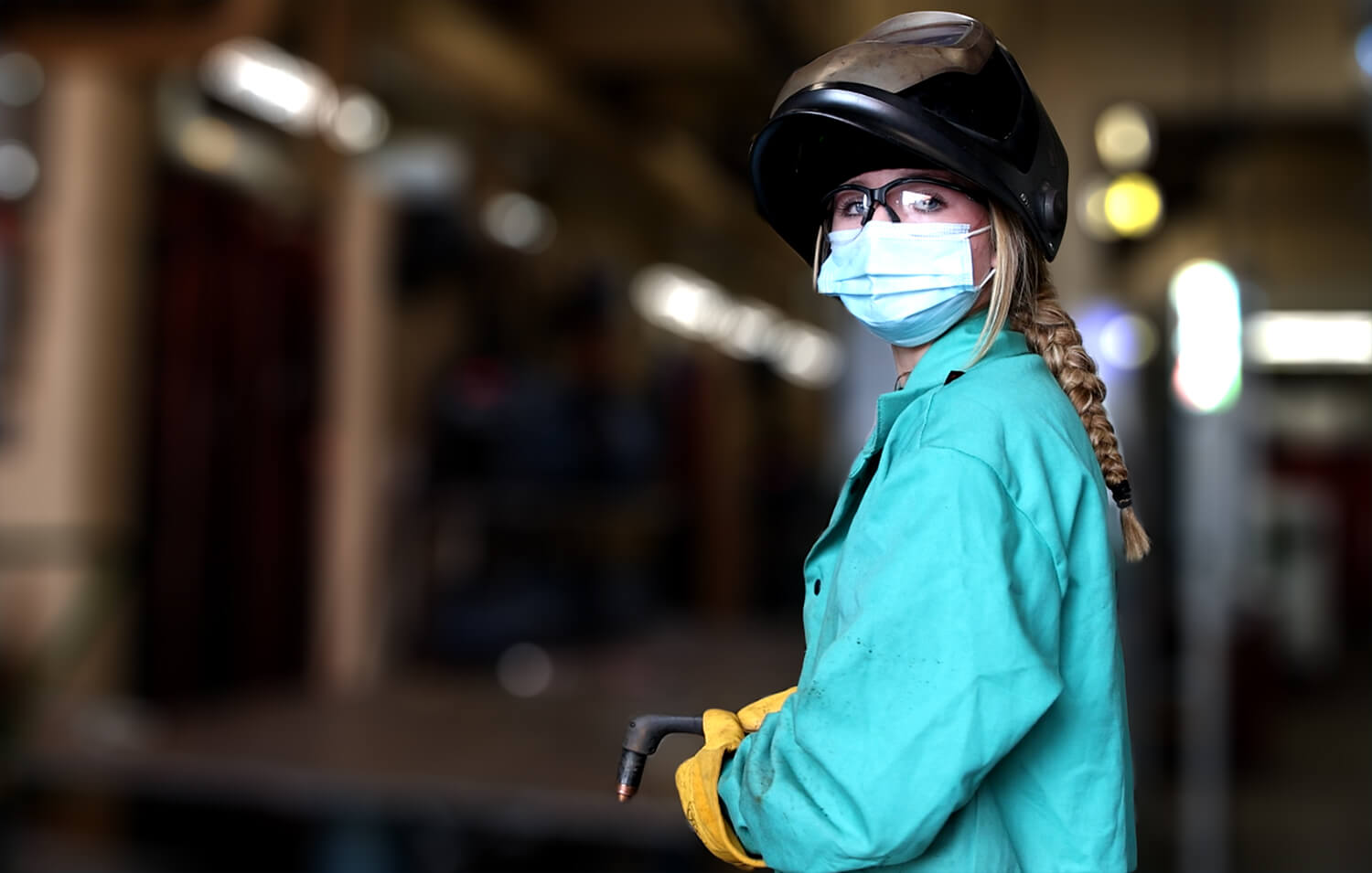 A welding student wearing a mask