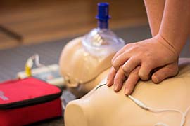 Close up of hands performing cpr on a cpr dummy