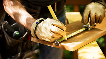 carpentry worker measuring wood for project