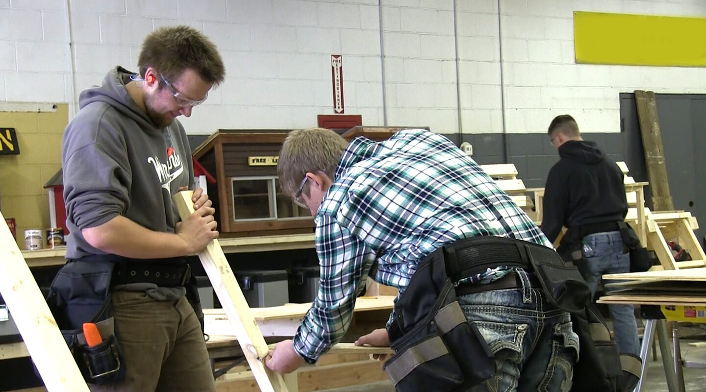 High school students doing hands-on work with construction