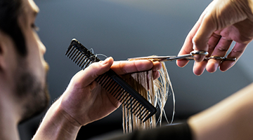 Cosmetologist cutting hair