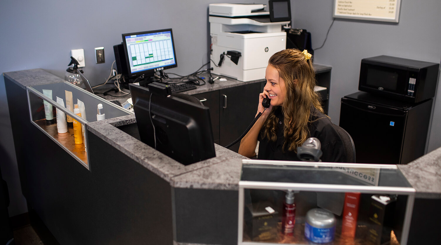 A cosmetology student doing receptionist work