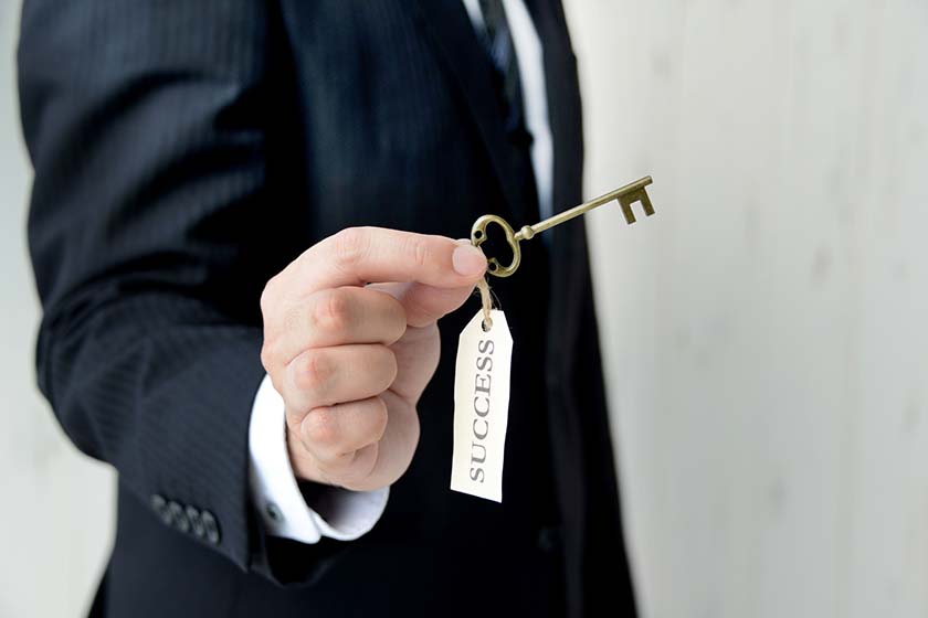 Man holding old fashioned key with label of 'success'